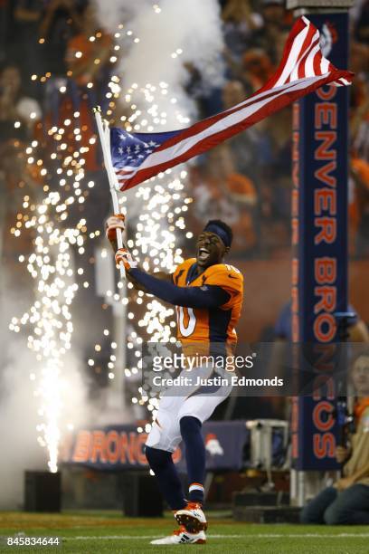 Wide receiver Emmanuel Sanders of the Denver Broncos is introduced to the game while carrying the American Flag at Sports Authority Field at Mile...