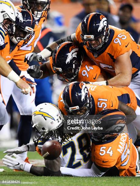 Brandon Marshall of the Denver Broncos forces a fumble on Melvin Gordon of the Los Angeles Chargers as Todd Davis and Derek Wolfe assist during the...