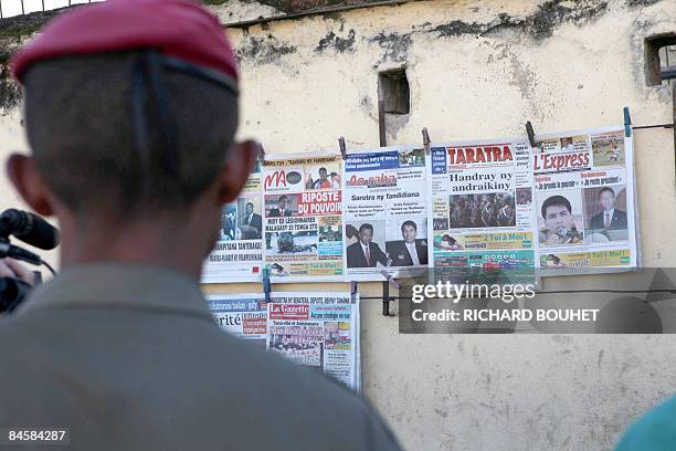 Soldier looks at front pages of newspapers on February 2, 2009 in Antananarivo as the mayor of the Madagascan capital, Andry Rajoelina, holds a...