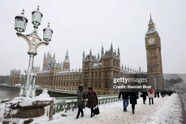 People cross Westminster Bridge with Clock Tower and the Houses of Parliament in the background after heavy snow falls across London and the United...