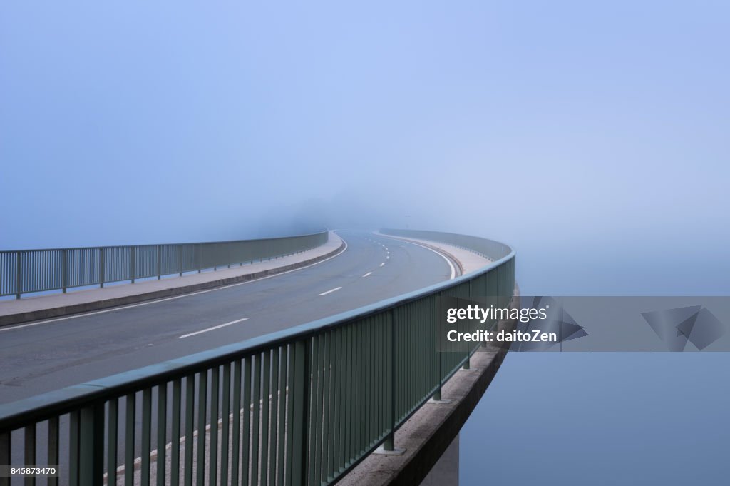 Bridge over Sylvenstein Reservoir disappearing in heavy fog, Sylvenstein Lake, Bavaria, Germany