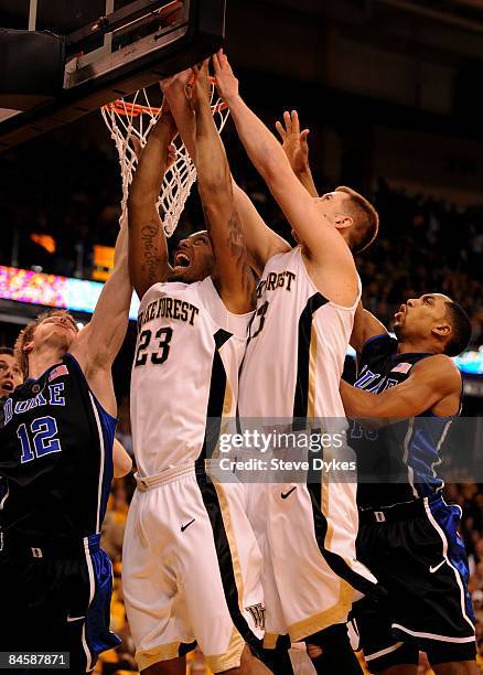 James Johnson and Chas McFarland of the Wake Forest Demon Deacons go up for a shot on Kyle Singler of the Duke Blue Devils in the first half of the...