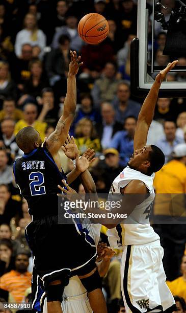 Nolan Smith of the Duke Blue Devils takes a shot over the outstretched arm of David Weaver of the Wake Forest Demon Deacons in the first half of the...