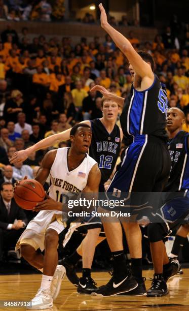 Ishmael Smith of the Wake Forest Demon Deacons looks to pass the ball on Kyle Singler and Brian Zoubek of the Duke Blue Devils in the first half of...