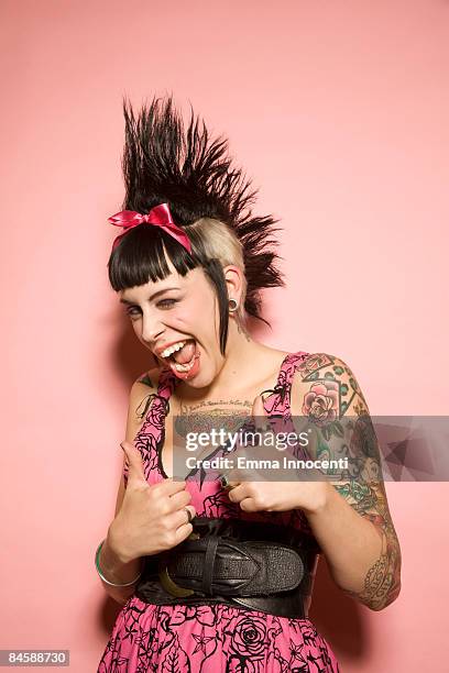 young woman with tattoos giving the thumbs-up - hair style stock-fotos und bilder