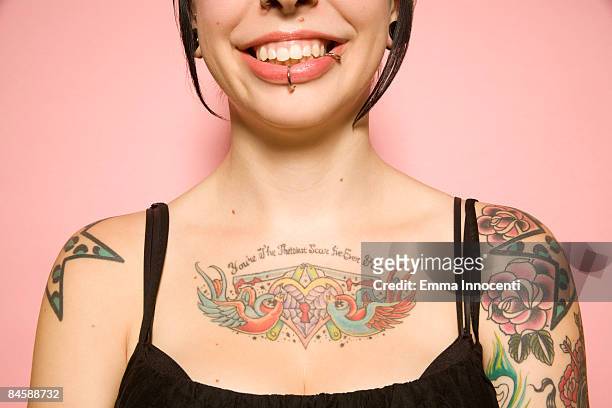 close-up of woman with tattoos on pink background - tattoo stockfoto's en -beelden