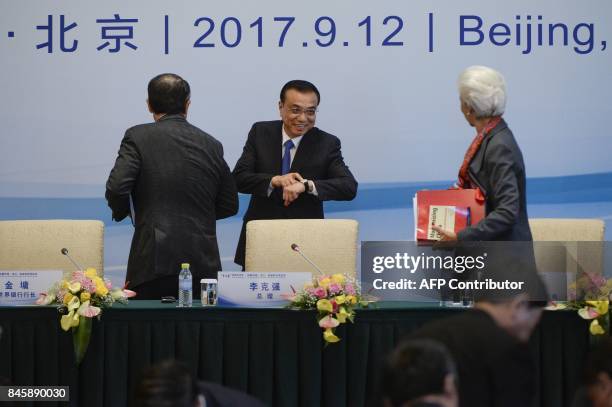 Chinese Premier Li Keqiang speaks to Managing Director of the International Monetary Fund Christine Lagarde as he points to his watch after a press...
