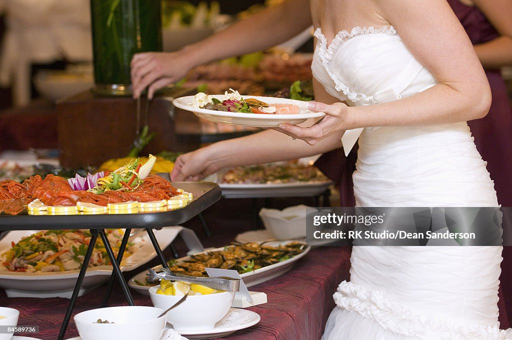 Bride getting food from buffet. 