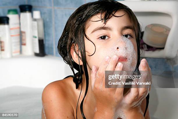 girl in bathtube washing her face - bathtube stock pictures, royalty-free photos & images