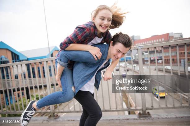Young Couple Piggyback On Bridge
