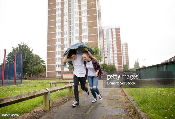 young couple run in the rain - apartment shower stock pictures, royalty-free photos & images