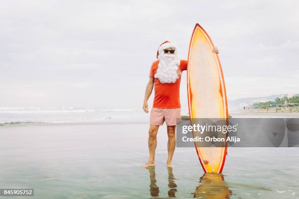 santa claus with surf board - surfing santa stock pictures, royalty-free photos & images