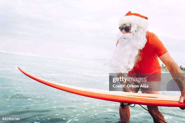 santa claus with surf board - surfing santa stock pictures, royalty-free photos & images