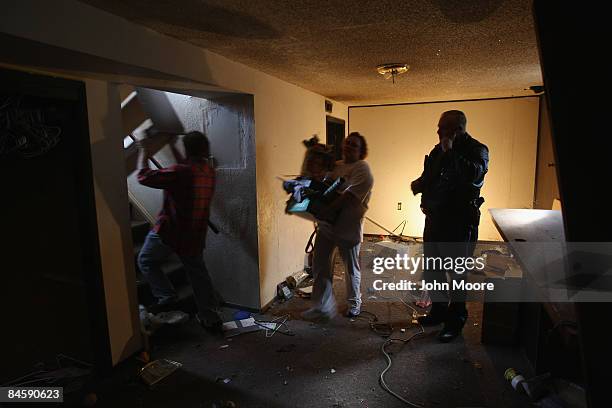 Adams Country sheriff's deputy Greg Barnett , supervises as an eviction team carries out a family's belongings during a foreclosure eviction February...