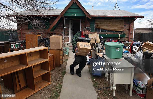 Chris Smith carries out his family's belongings during an official eviction from his foreclosed house on February 2, 2009 in Adams County, Colorado....