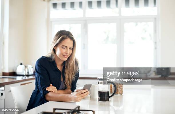 iniziare la giornata con uno scorrimento attraverso il social network - woman home sit foto e immagini stock