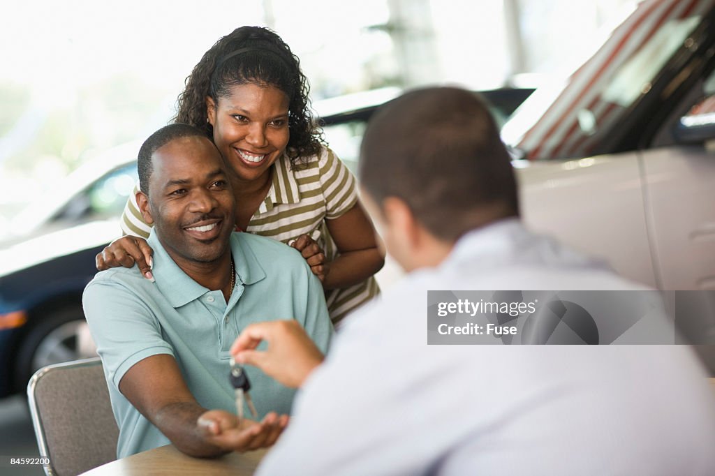 Salesman Giving Man Keys to New Car