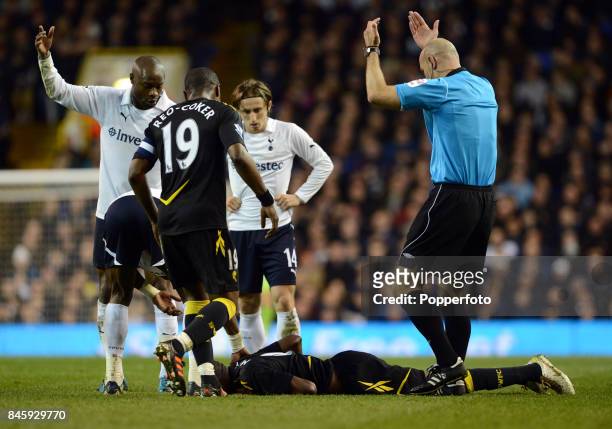 Referee Howard Webb calls for assistant with Fabrice Muamba of Bolton lying on the ground awaiting medical treatment after suffering a heart attack...