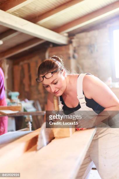carpenters sawing - berufliche beschäftigung stock pictures, royalty-free photos & images
