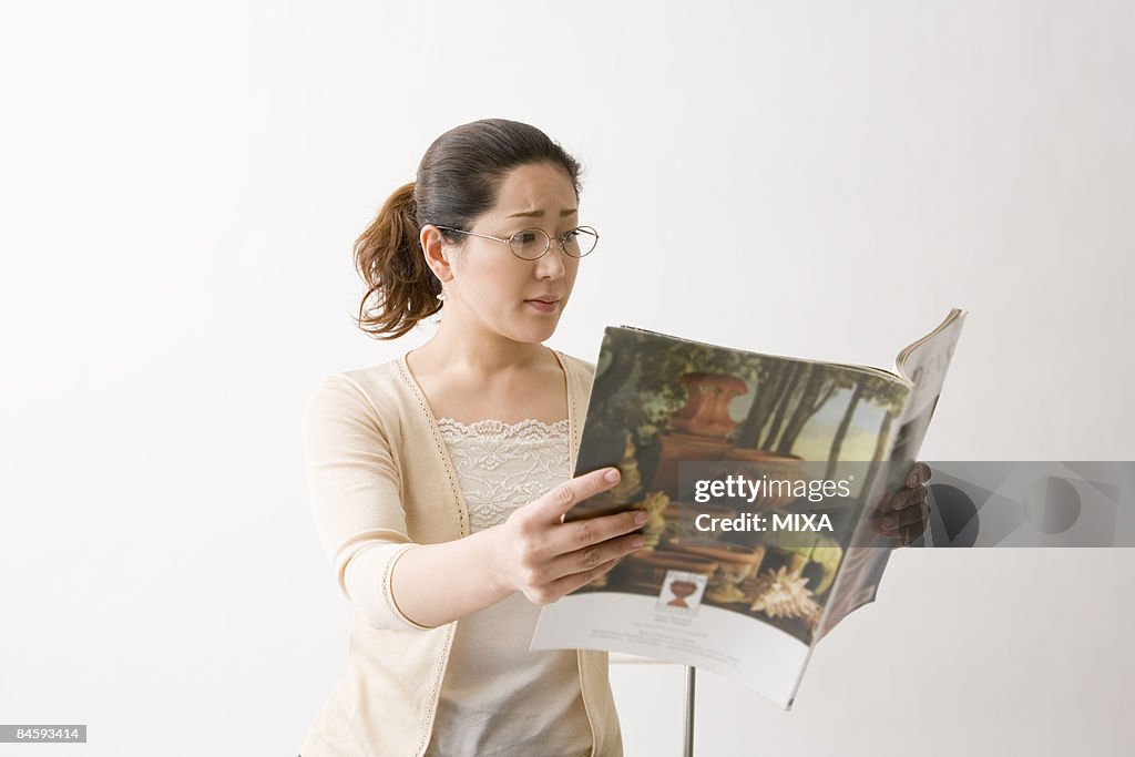 Mature woman reading magazine