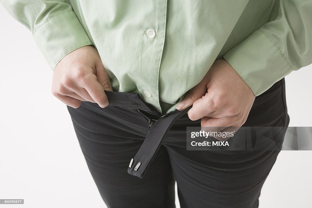 Mid adult woman putting on pants