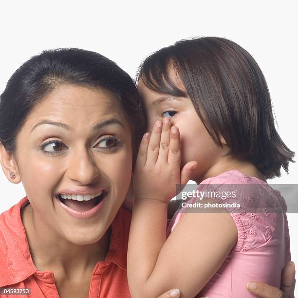 girl whispering into her mother's ear - hand cupped ear stock pictures, royalty-free photos & images