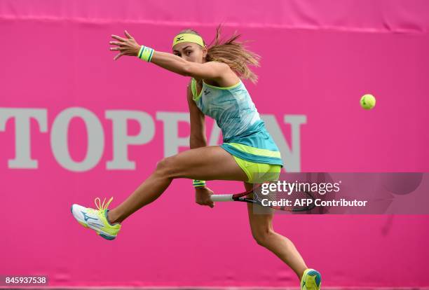 Aleksandra Krunic of Serbia returns a shot between her legs to Kimiko Date of Japan during their first round match of the Japan Women's Open tennis...