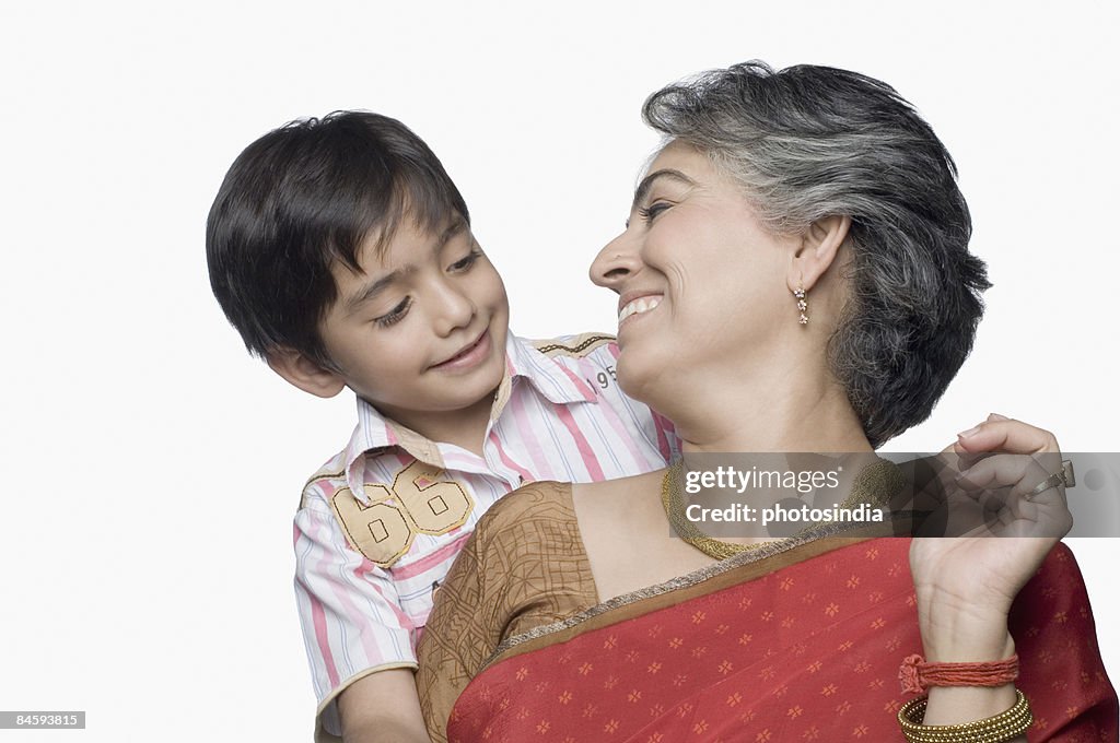 Close-up of a mature woman and her grandson looking at each other and smiling