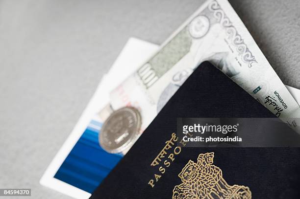 close-up of an indian passport with money and an airline ticket - indian rupee note stock pictures, royalty-free photos & images