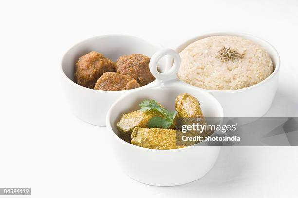 close-up of koftas curry and boiled rice with meatballs in bowls - indian food bowls stock-fotos und bilder