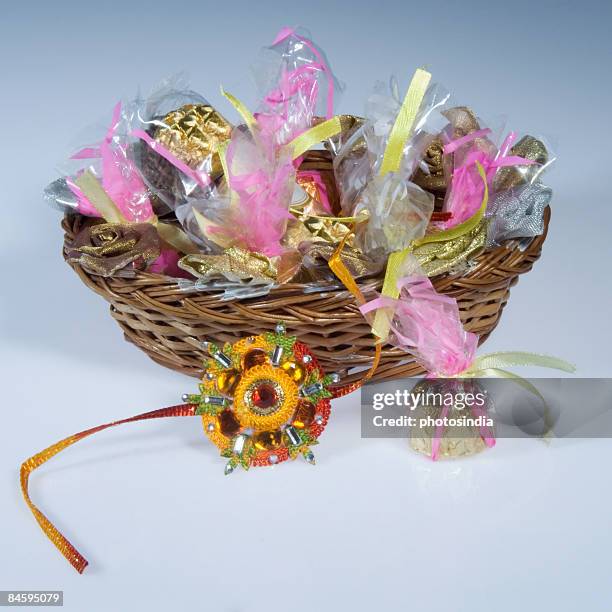 close-up of a rakhi with sweets in a wicker basket - raksha bandhan stock-fotos und bilder