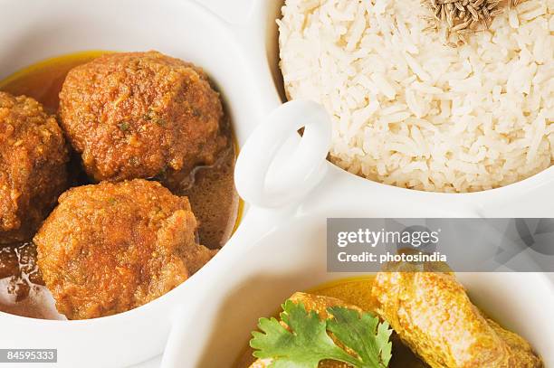 close-up of koftas curry and boiled rice and meatballs in bowls - indian food bowls stock-fotos und bilder