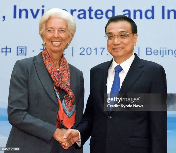 Chinese Premier Li Keqiang and International Monetary Fund Managing Director Christine Lagarde shake hands at the Diaoyutai State Guesthouse in...