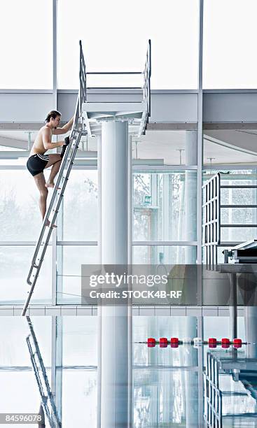 man climbing up to a highboard in a indoor swimming pool - hopptorn bildbanksfoton och bilder