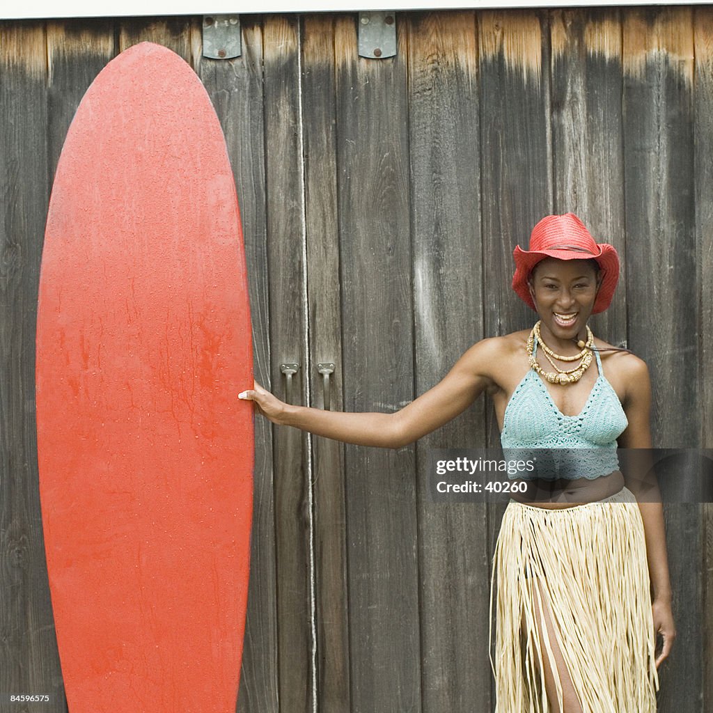Portrait of a mid adult woman holding a surfboard and smiling