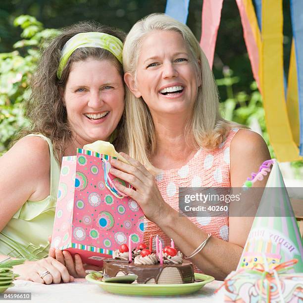 mature woman celebrating her birthday with her friend - older woman birthday stock pictures, royalty-free photos & images