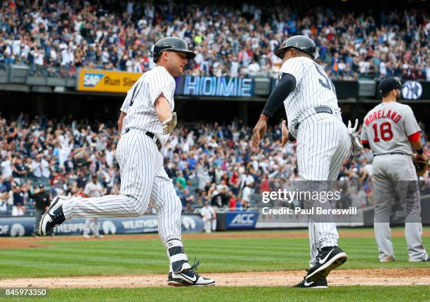 Matt Holliday of the New York Yankees is greeted by first base coach Tony Pena of the New York Yankees as he rounds the bases on his three run homer...