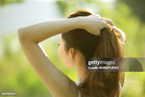 woman pulling back hair - woman pulling hair back stock pictures, royalty-free photos & images