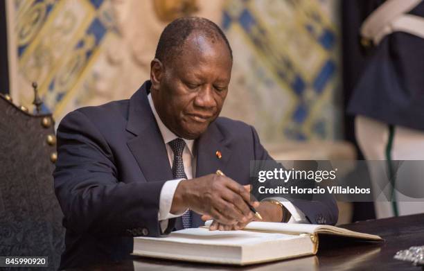 The President of Ivory Coast Alassane Dramane Ouattara signs the honors book in Belem Palace on September 12, 2017 in Lisbon, Portugal. The President...