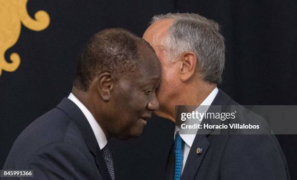 The President of Ivory Coast Alassane Dramane Ouattara embraces with Portuguese President Marcelo Rebelo de Sousa during the press conference at the...