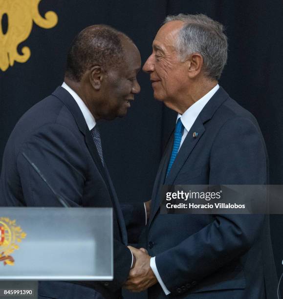 The President of Ivory Coast Alassane Dramane Ouattara embraces with Portuguese President Marcelo Rebelo de Sousa during the press conference at the...