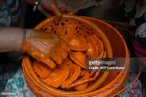 An Indian potter prepares traditional decorative earthen diyas-oil lamps, ahead of the Hindu festival of Navaratri, at the Kumbharwada potters colony...