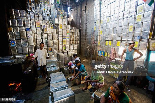 Women recycle one-gallon cooking oil cans in the Dharavi slum on February 3, 2009 in Mumbai, India. The re-development of the Jari Mari slum,...