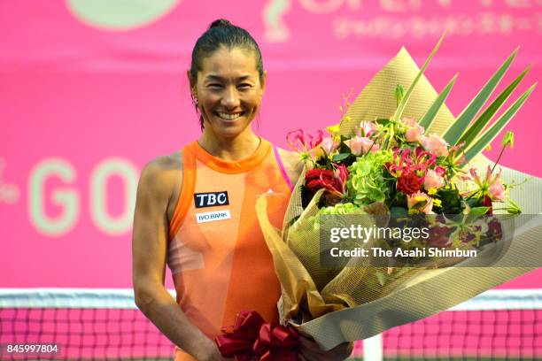 Kimiko Date of Japan poses for photographs during her retirement ceremony after her defeat in the singles first round match against Aleksandra Krunic...