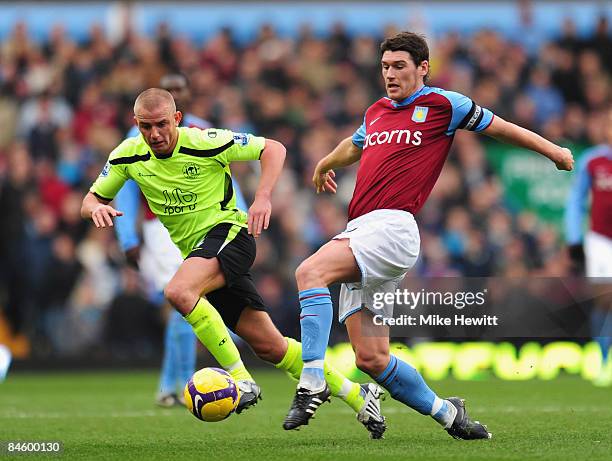 Gareth Barry of Aston Villa is challenged by Lee Cattermole of Wigan during the Barclays Premier League match between Aston Villa and Wigan Athletic...