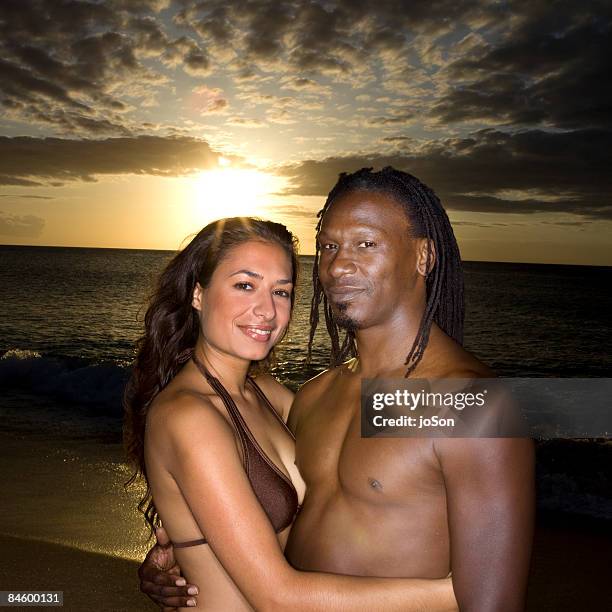 couple embracing on beach, sunset - sunset beach fotografías e imágenes de stock