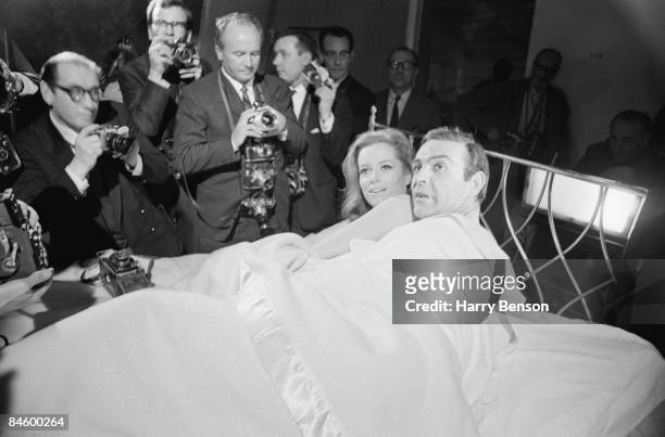 Actors Sean Connery and Luciana Paluzzi being photographed in bed on the set of the James Bond film 'Thunderball', 8th March 1965.