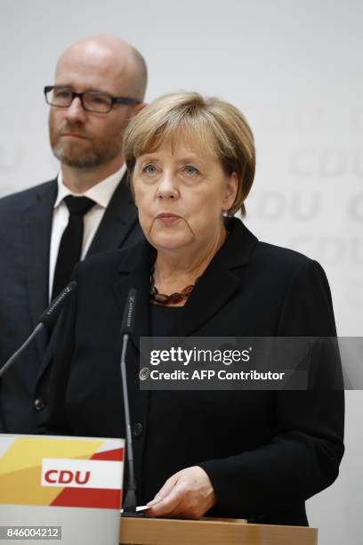 German Chancellor Angela Merkel stands next to CDU secretary general Peter Tauber as she gives a statement on September 12, 2017 in Berlin to express...