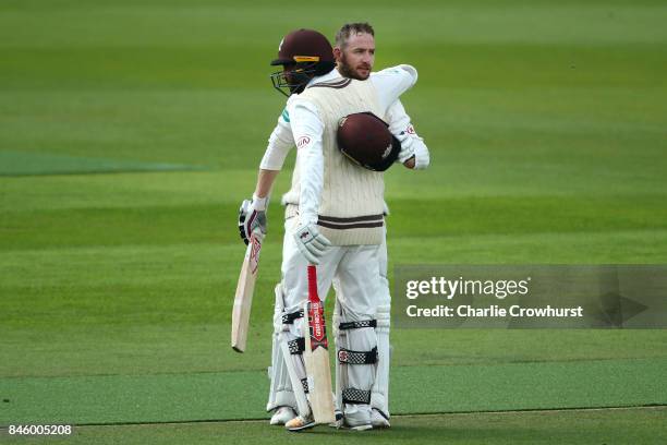 Surrey's Mark Stoneman celebrates his century with team mate Ryan Patel during day one of the Specsavers County Championship Division One match...