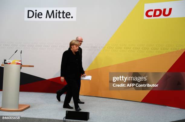 German Chancellor Angela Merkel is accompanied by CDU secretary general Peter Tauber as she leaves after giving a statement on September 12, 2017 in...